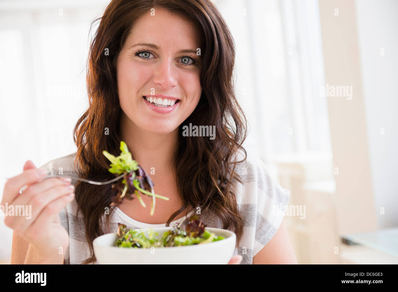 Ritratto di giovane donna di mangiare insalata fresca Foto Stock