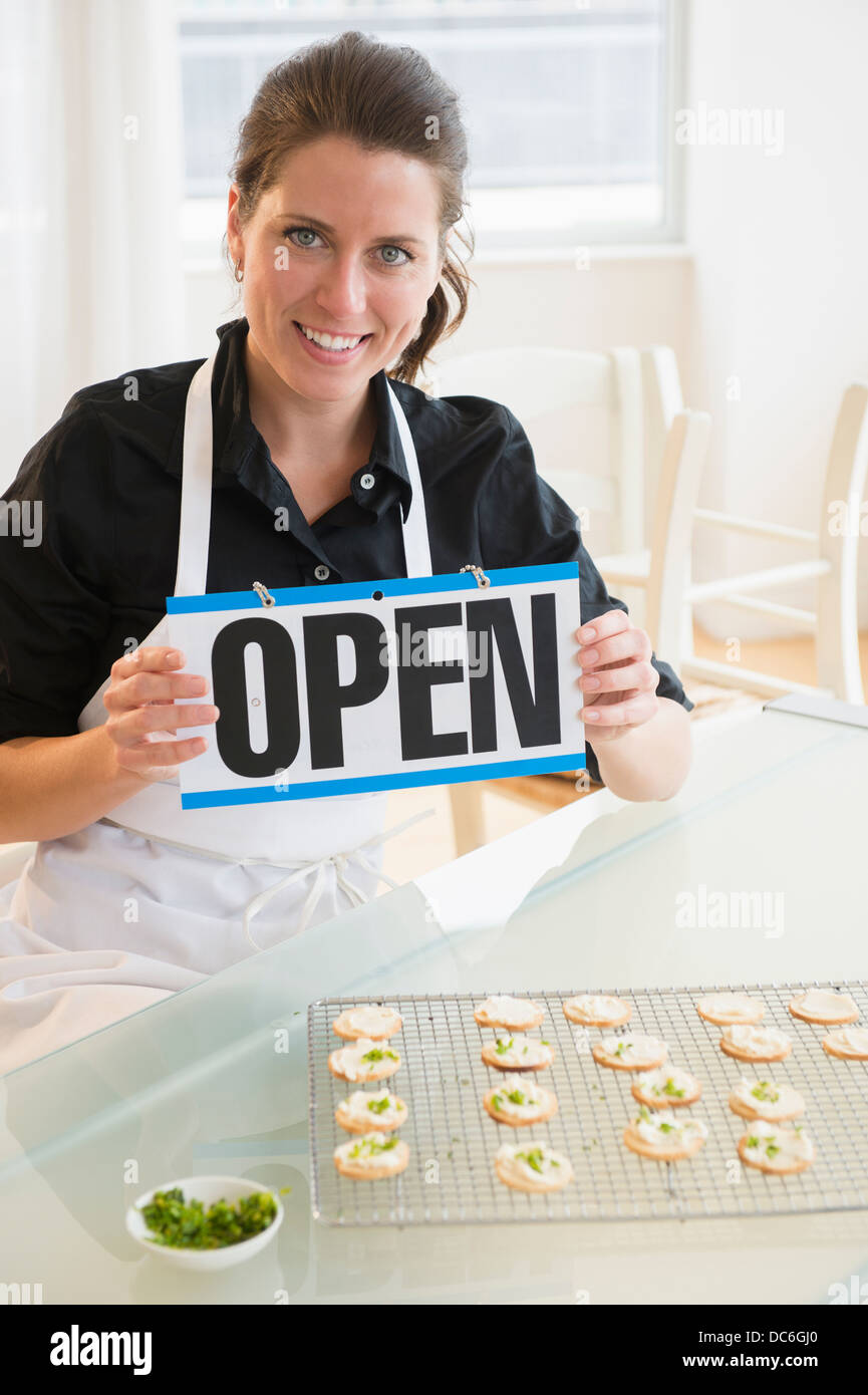 Ritratto di donna tenendo aperte segno Foto Stock