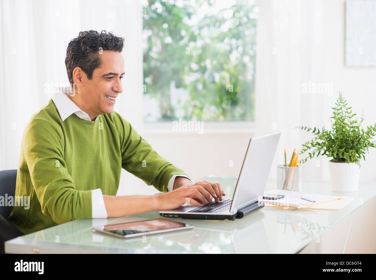 Ritratto di uomo che lavora sul portatile a casa Foto Stock