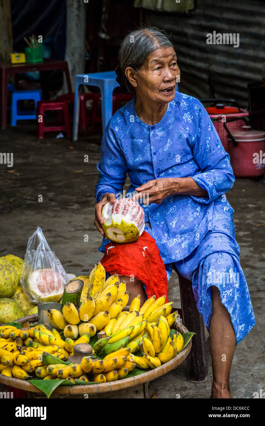 Una signora anziana per la vendita di frutta al Thien Mu Pagoda vicino a tonalità, Vietnam, in Asia. Foto Stock