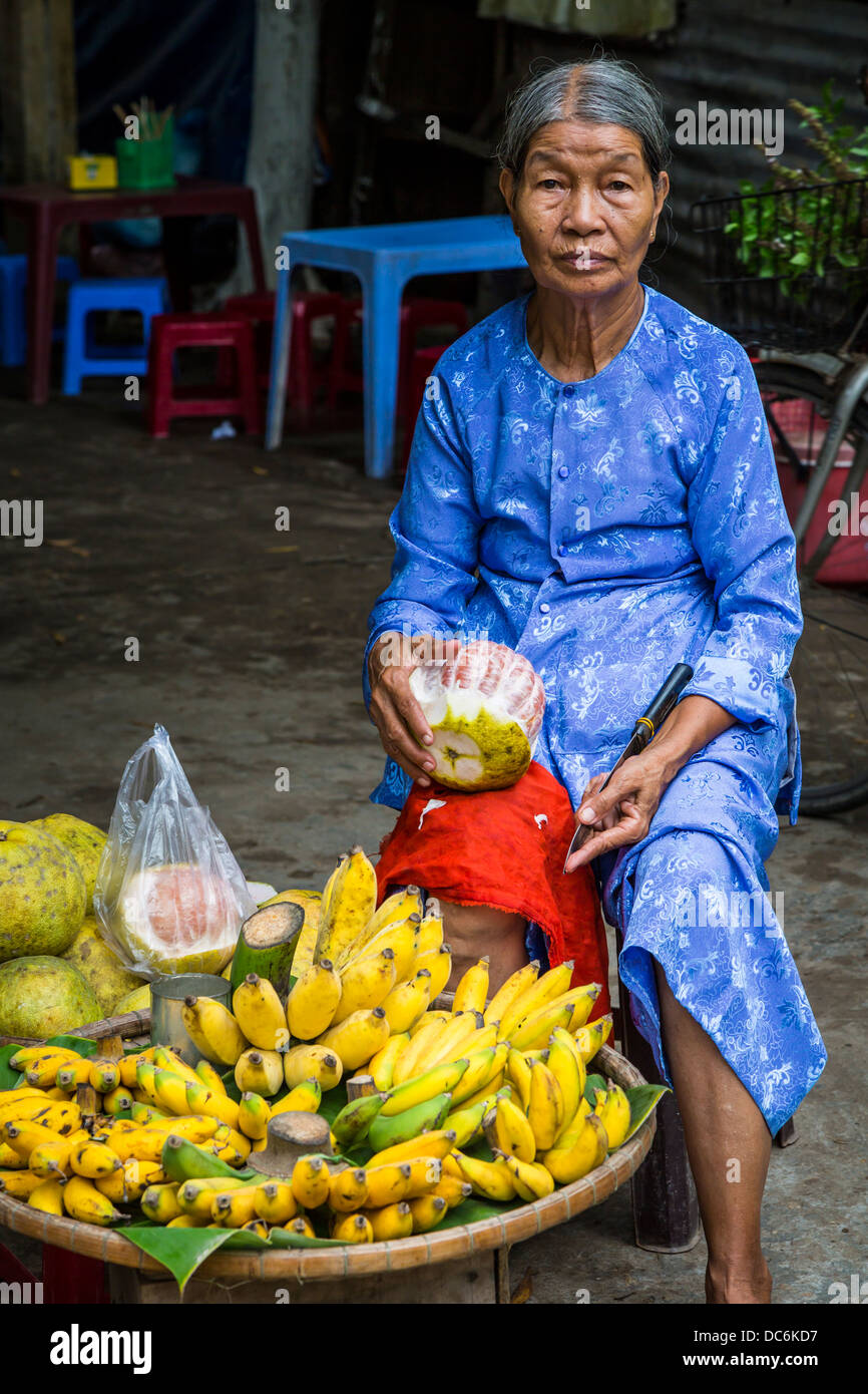 Una signora anziana per la vendita di frutta al Thien Mu Pagoda vicino a tonalità, Vietnam, in Asia. Foto Stock