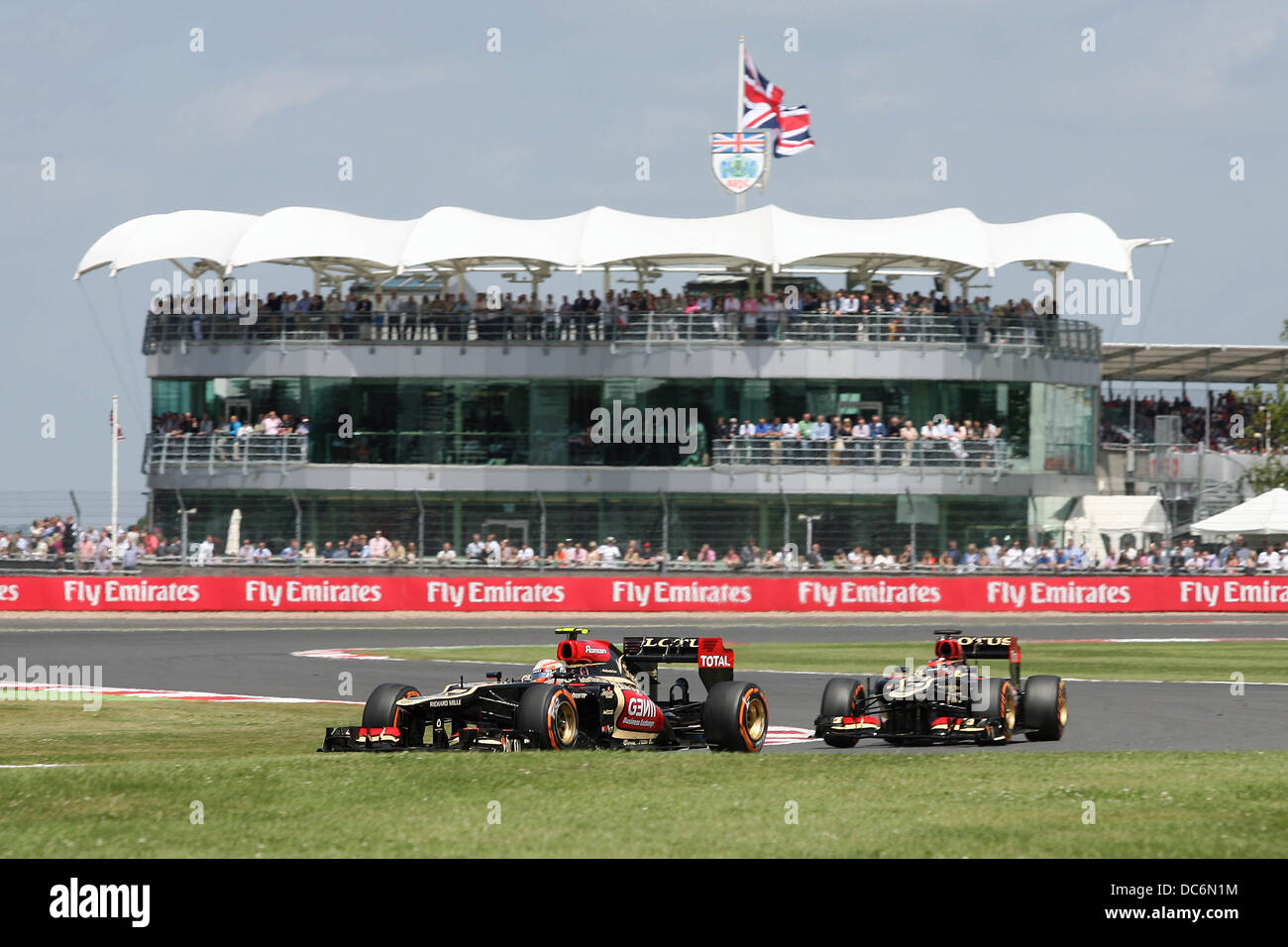 Romain Grosjean e Kimi Raikkonen di Lotus F1 passa la BRDC Clubhouse al 2013 F1 Gran Premio di Gran Bretagna a Silverstone. Foto Stock