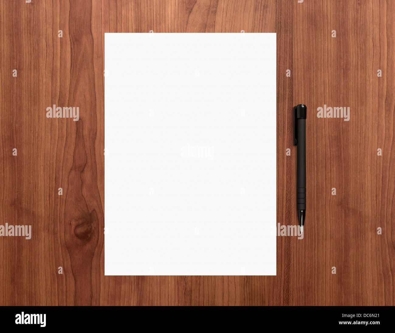 Vuoto di carta bianca con penna su una scrivania in legno. Grafici di alta qualità collage. Foto Stock