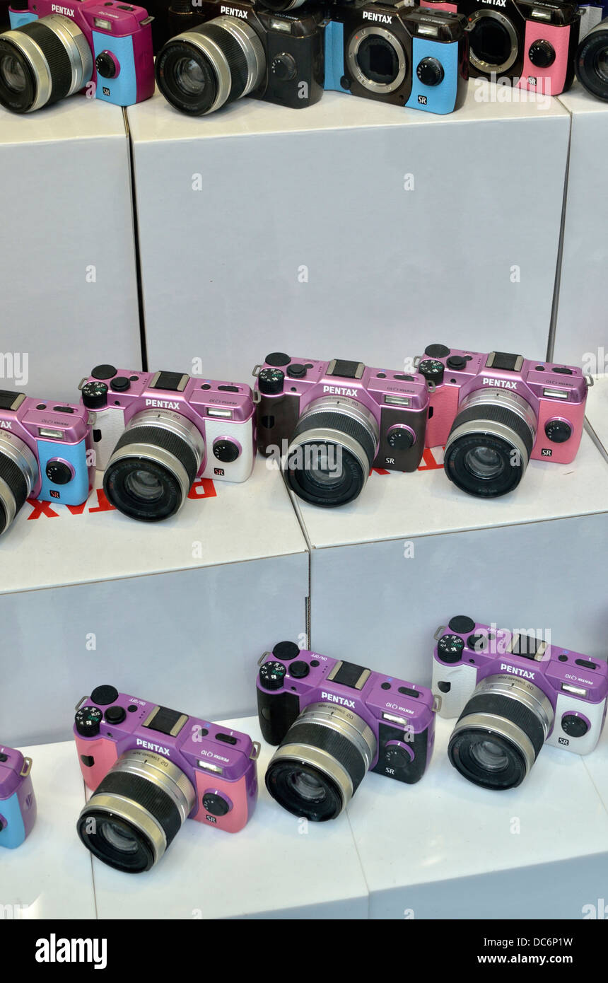 Colorate le fotocamere compatte digitali sul display nella vetrina di un negozio. Foto Stock