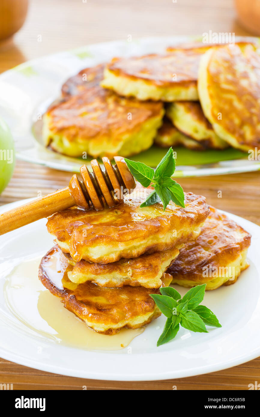 Frittelle dolci con mele e miele su una piastra Foto Stock