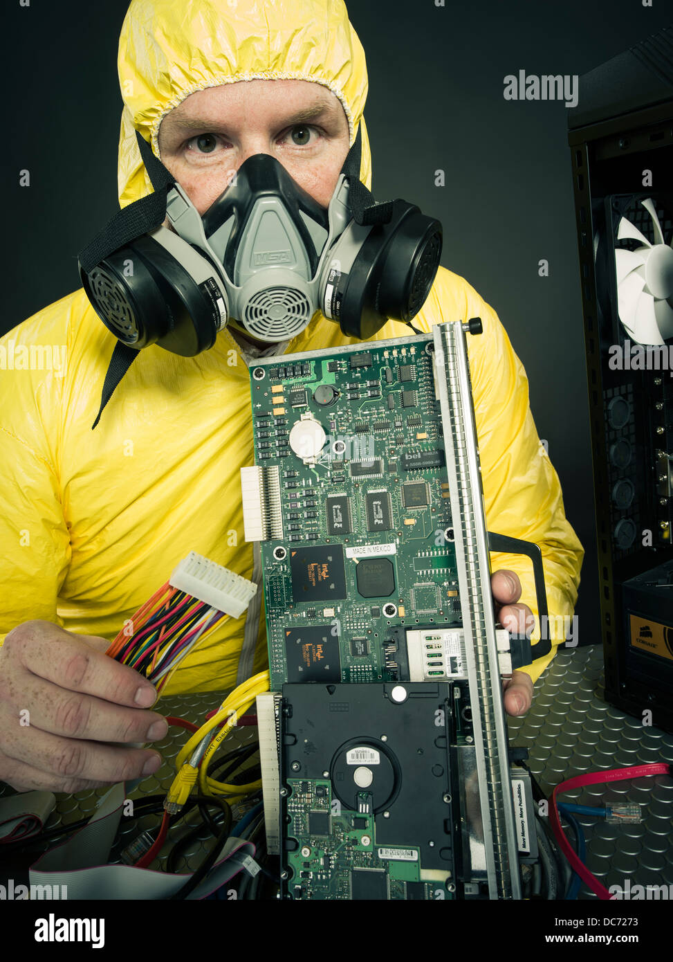 L uomo che si occupano di computer virus () figurativi o sostanze chimiche tossiche di metalli pesanti con il computer e con vari componenti hardware Foto Stock