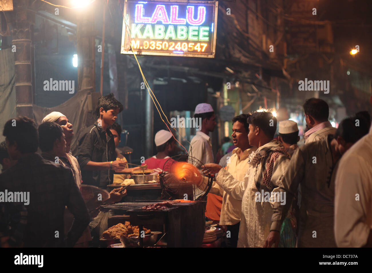 I musulmani si radunano attorno a un cibo stallo in Delhi, in India, in occasione del festival di Eid. Foto Stock