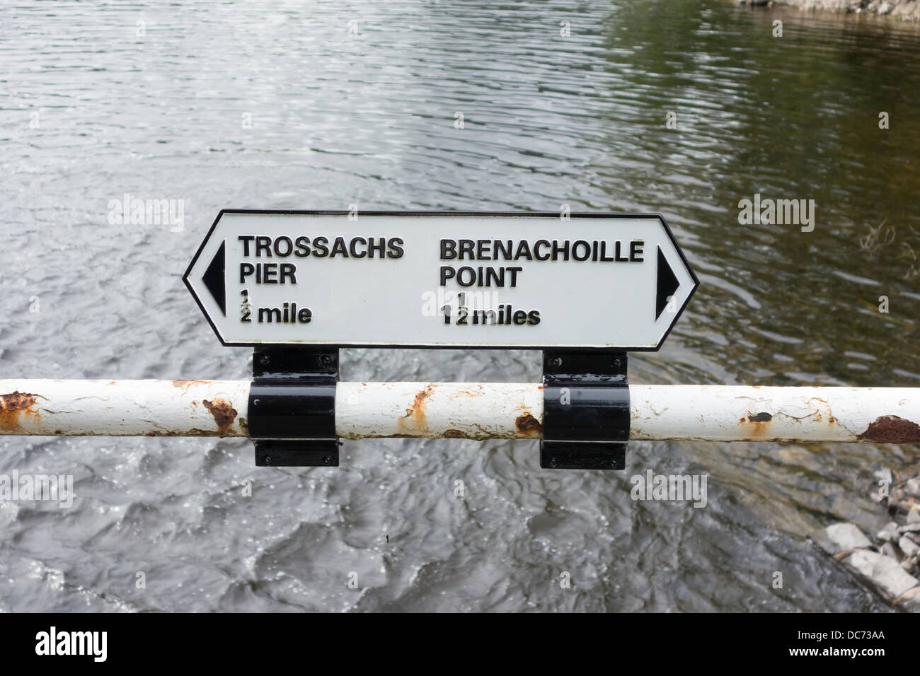 Cartello sul corrimano da un percorso lungo il Loch Katrine in Scozia che mostra Trossachs Pier ½ miglio e punto Brenachoille 11/2 miglio Foto Stock