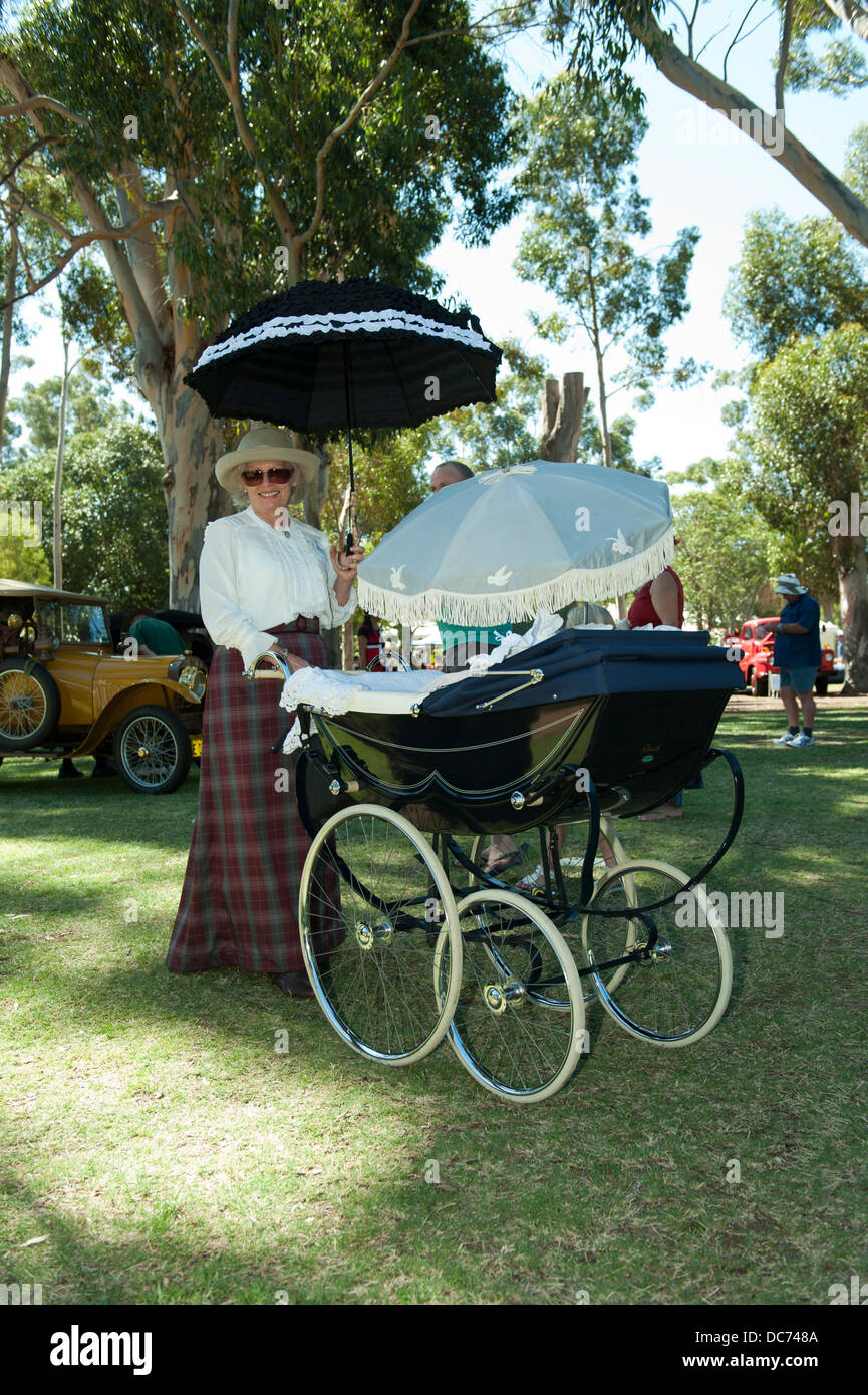 La donna nel periodo vestito con un vintage Osnath mansardati la PRAM. Foto Stock