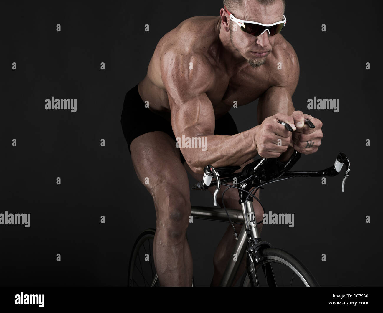 Triatleta muscolare sulla bicicletta da corsa Foto Stock