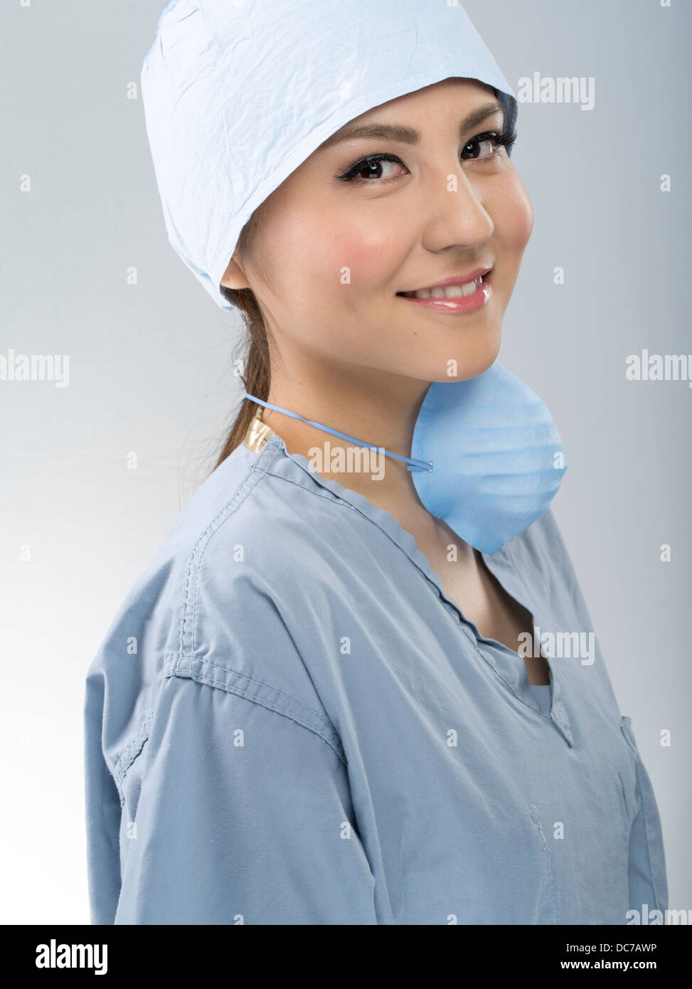 Medic femmina indossando scrub chirurgico il cappuccio e la maschera Foto Stock