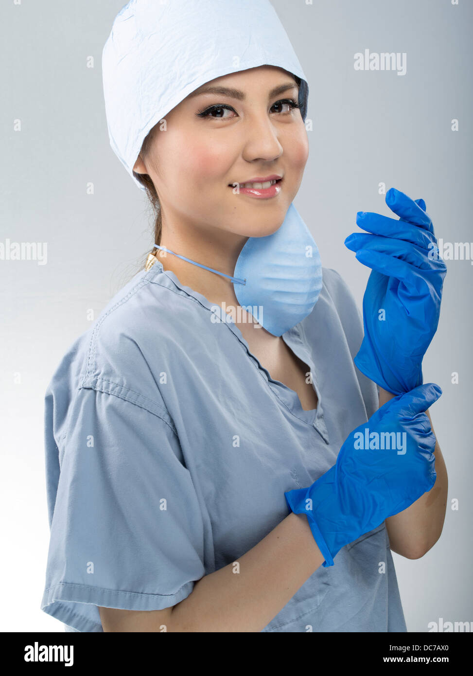 Medic femmina indossando scrub chirurgico il cappuccio e la maschera Foto Stock