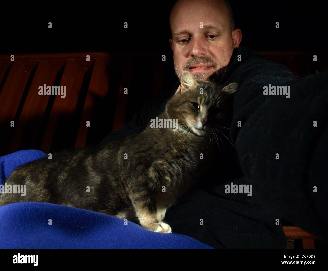 Uomo e gatto con sfondo scuro Foto Stock