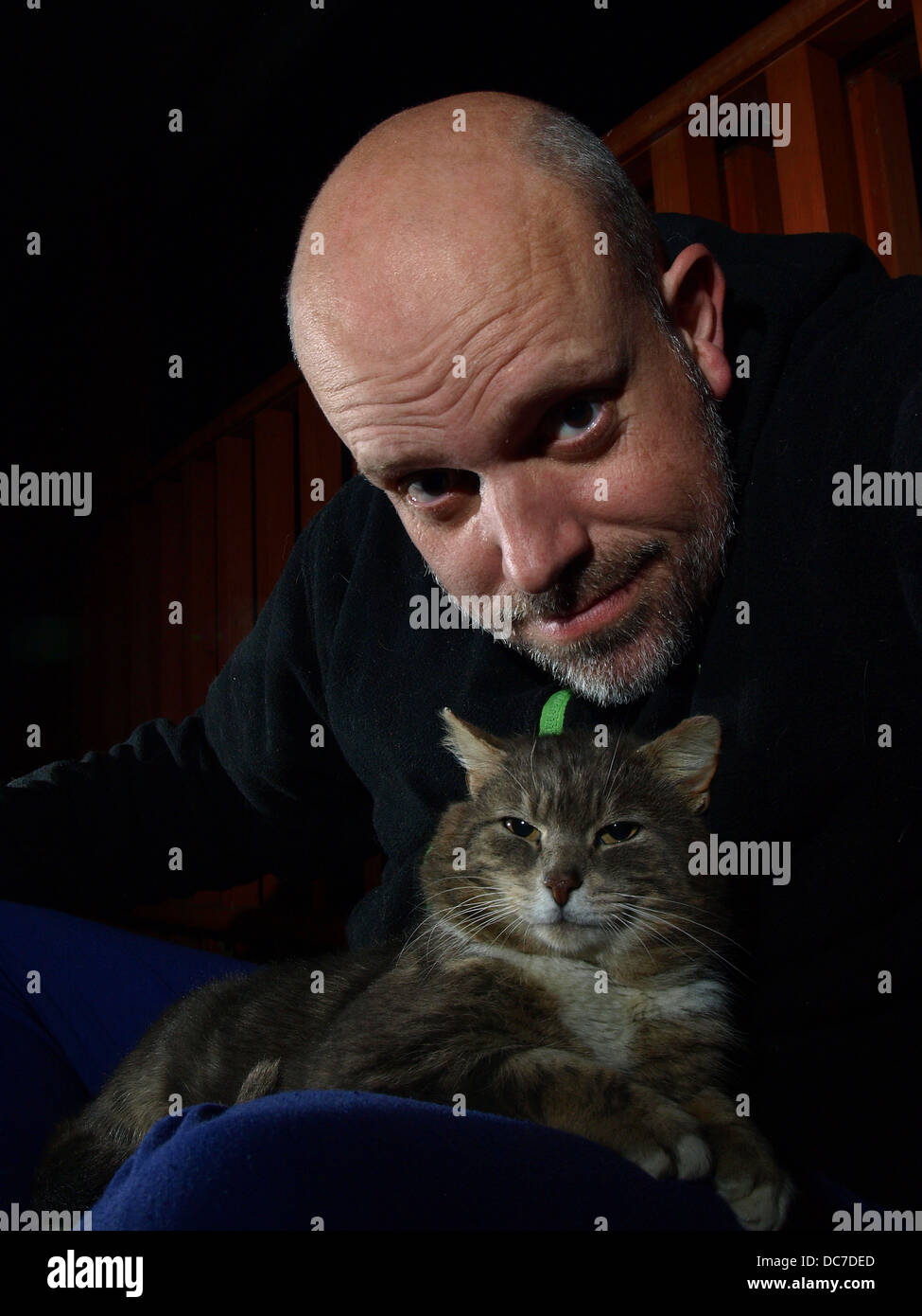 Uomo e gatto con sfondo scuro Foto Stock