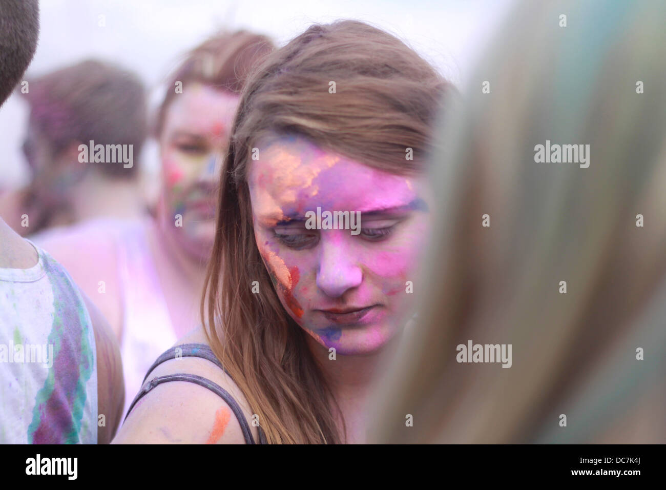 Ragazza coperto in blu holi colore colore in polvere divertimento eccitare gig festival ridere coperta faccia donna femmina Foto Stock