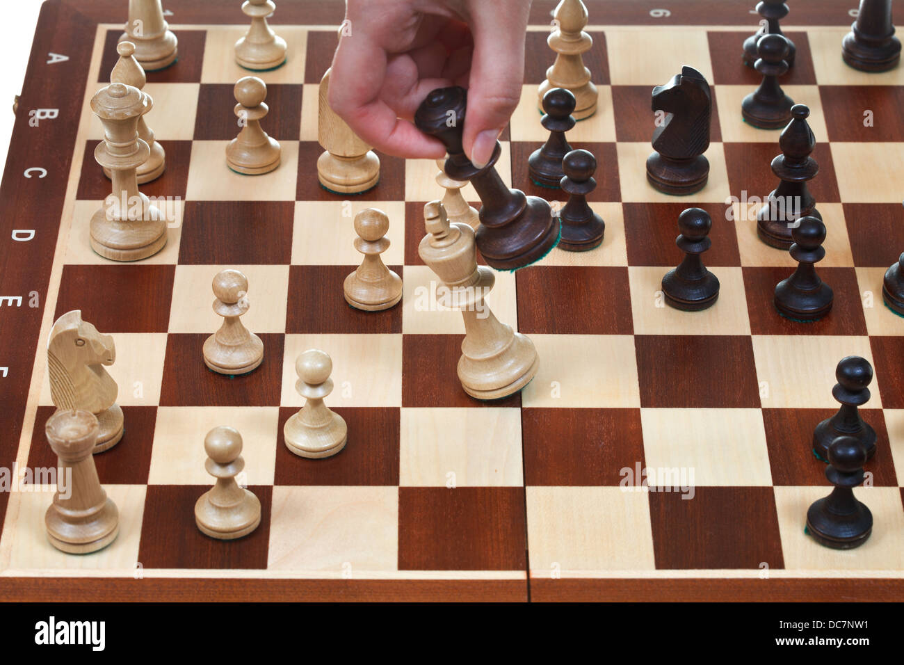 Mano con re nero bussa re bianco sulla scacchiera nel gioco degli scacchi Foto Stock