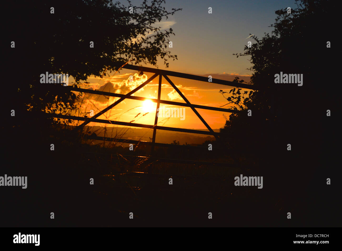 Il tramonto visto attraverso un cancello Foto Stock