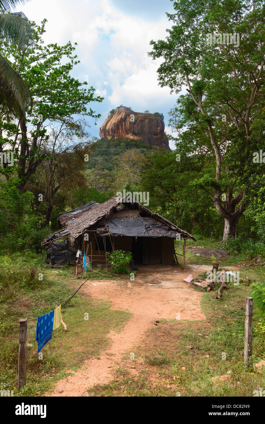 Baracca di fronte alta roccia sotto verde foresta. Sigiriya, Lion Rock con rock antica fortezza. Sri Lanka Foto Stock