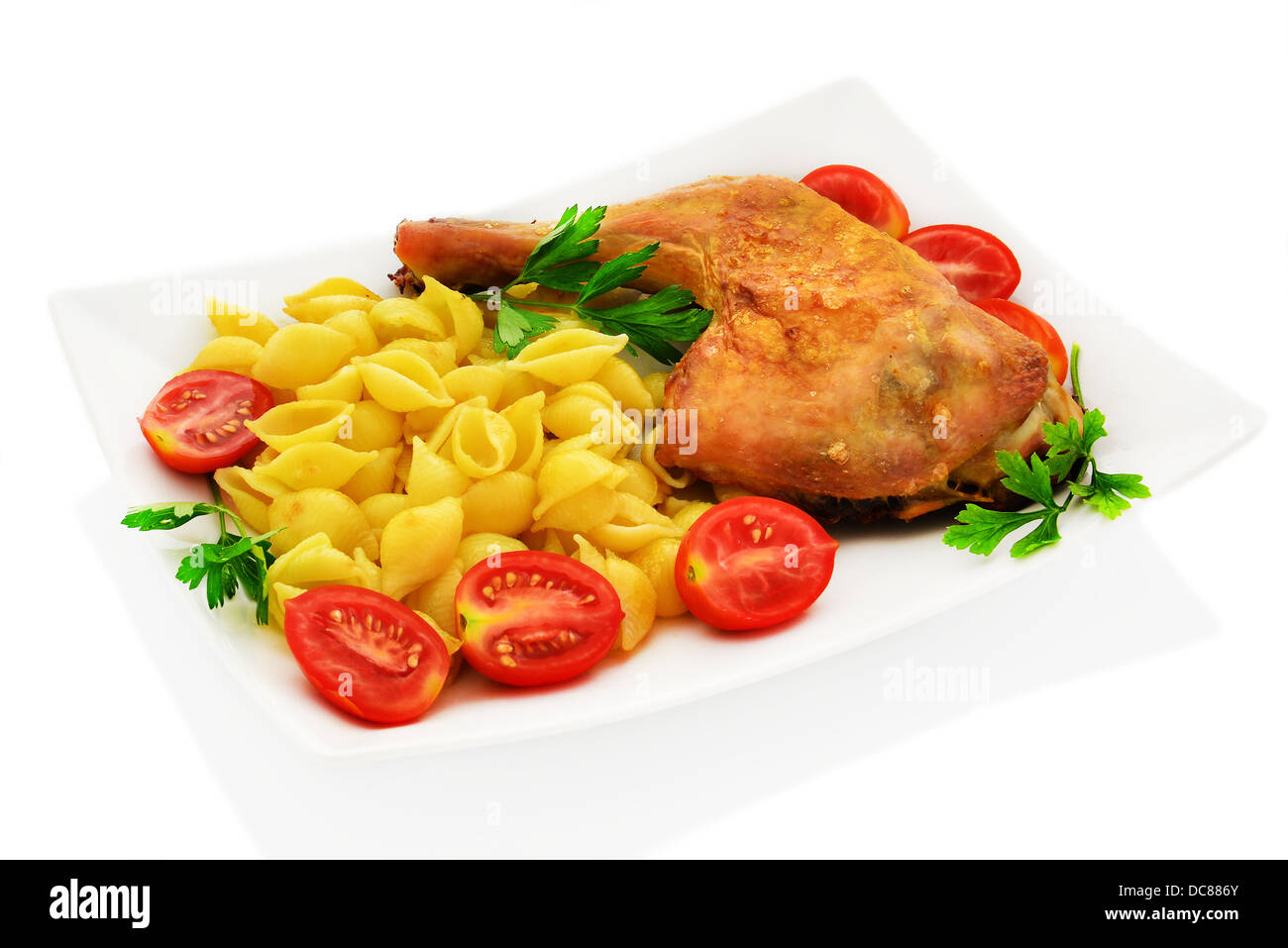 Pollo con pasta conchiglie, pomodorini e prezzemolo. Foto Stock