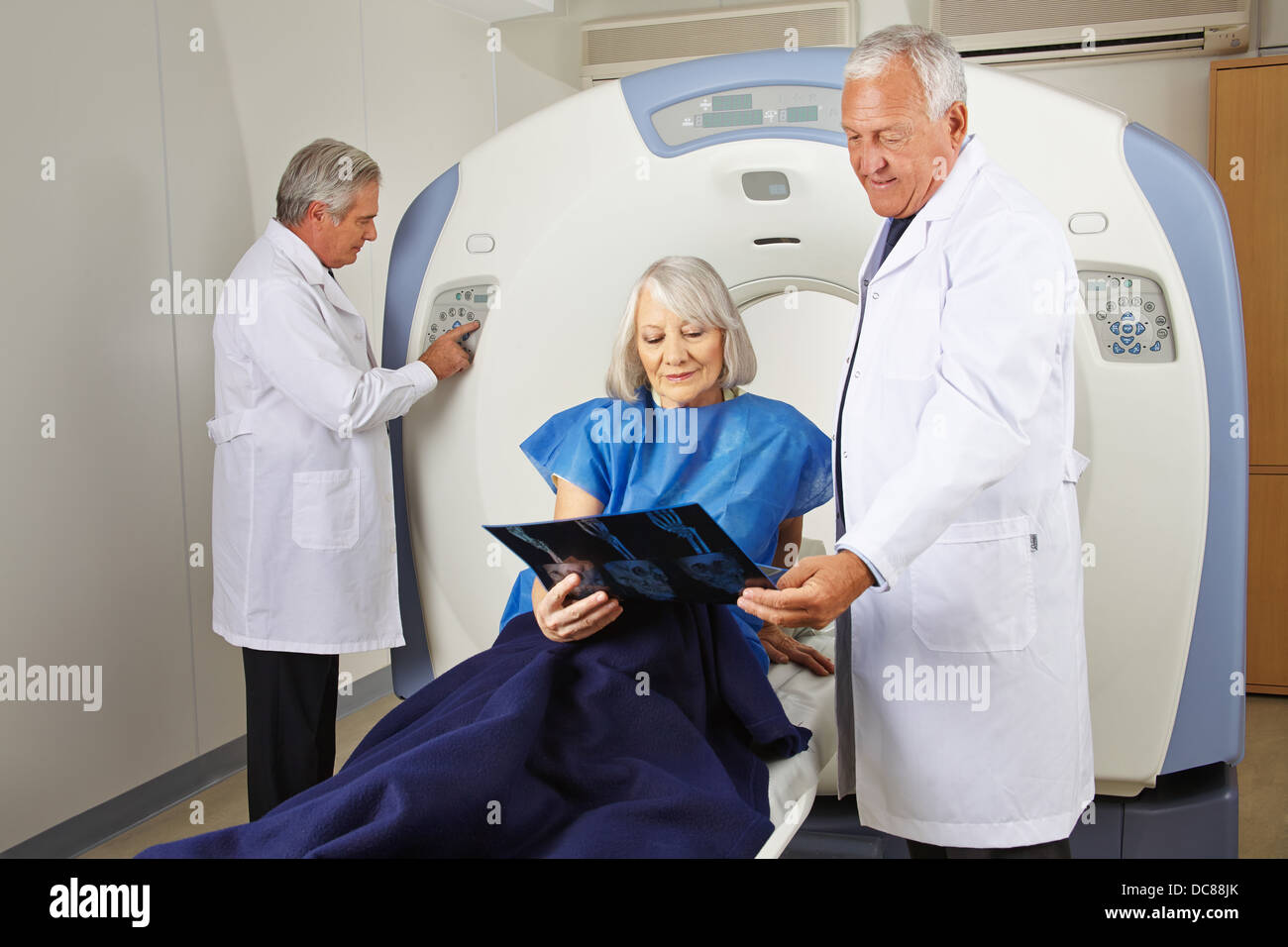 Senior paziente con immagine a raggi x e i medici a MRI scan in radiologia Foto Stock