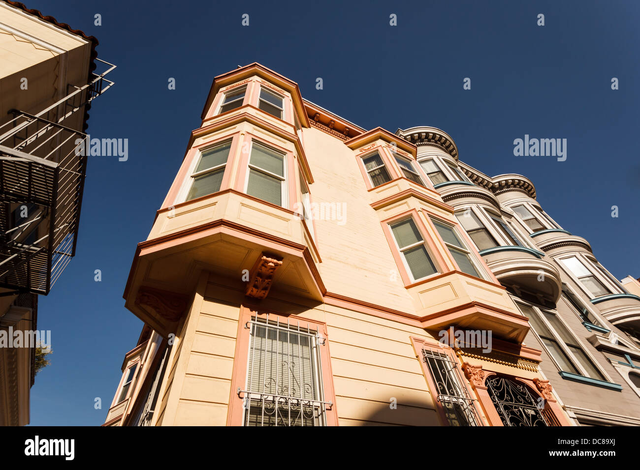 Skyward vista della bella baia finestra dettagli architettonici su 3 piani di San Francisco, California angolo casa di riga Foto Stock