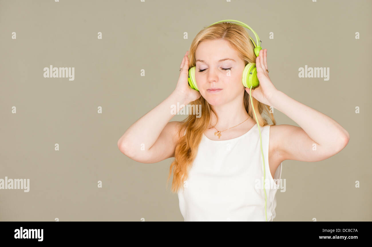 Ritratto di giovane donna bionda adolescente con gli occhi chiusi per ascoltare musica Foto Stock