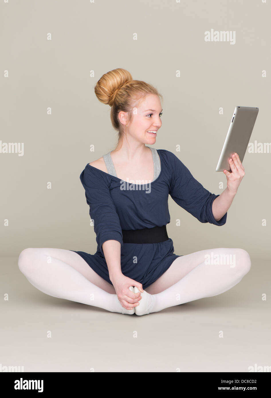 Bionda e giovane adolescente di sesso femminile in abito di balletto tenendo un tablet pc Foto Stock