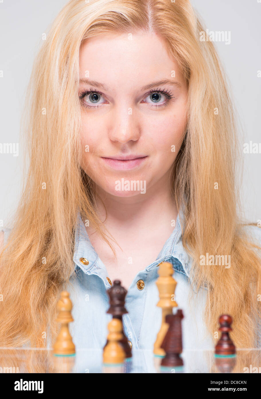 Giovane donna bionda e pezzi di scacchi Foto Stock
