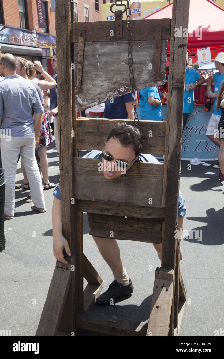 L uomo si immagina che cosa era come tornare indietro quando durante la Rivoluzione Francese. Ghigliottina il giorno della Bastiglia, Brooklyn, New York. Foto Stock