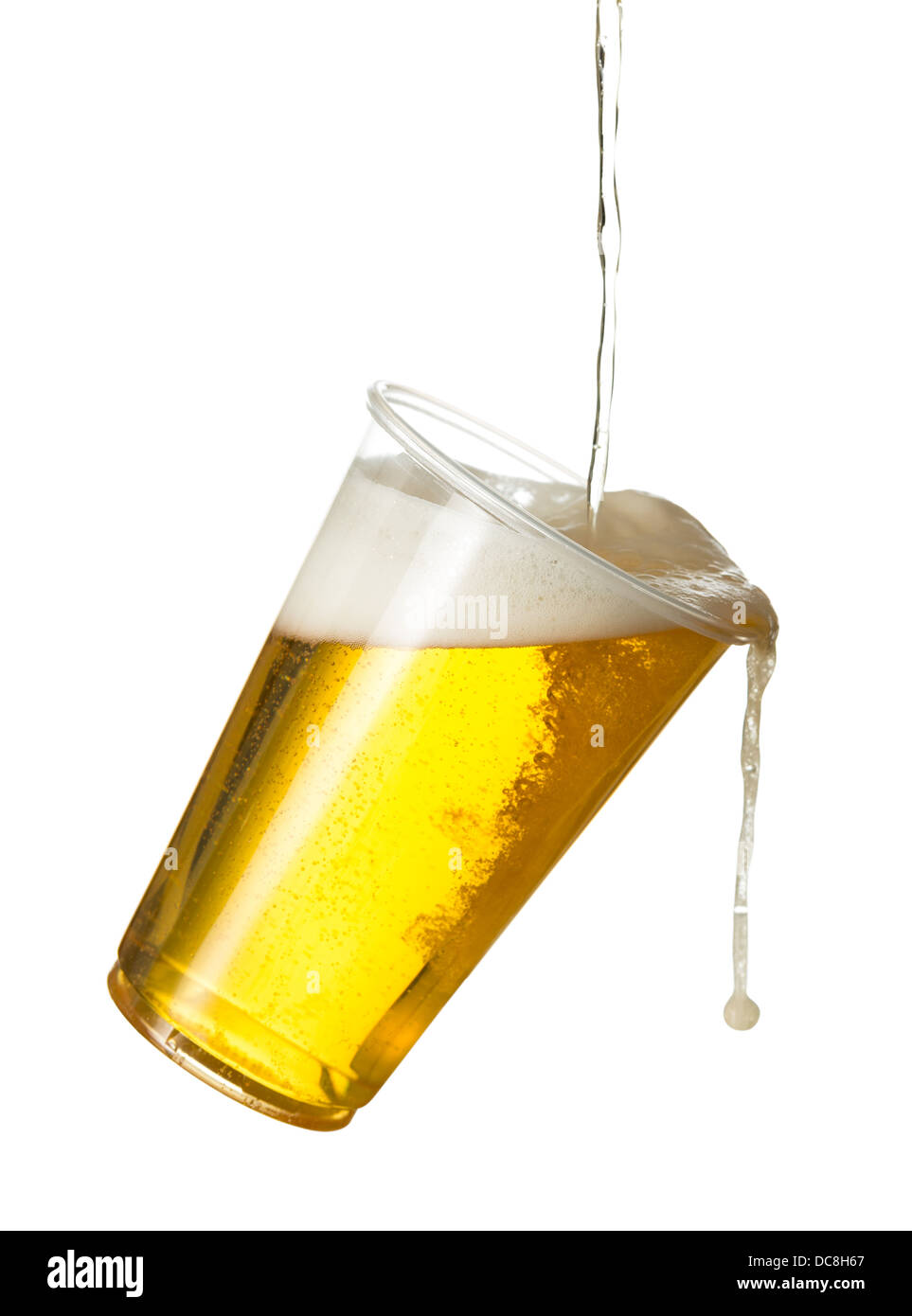 Versare la birra lager in una plastica monouso di pinta di vetro - fuoriuscita / oltre Foto Stock