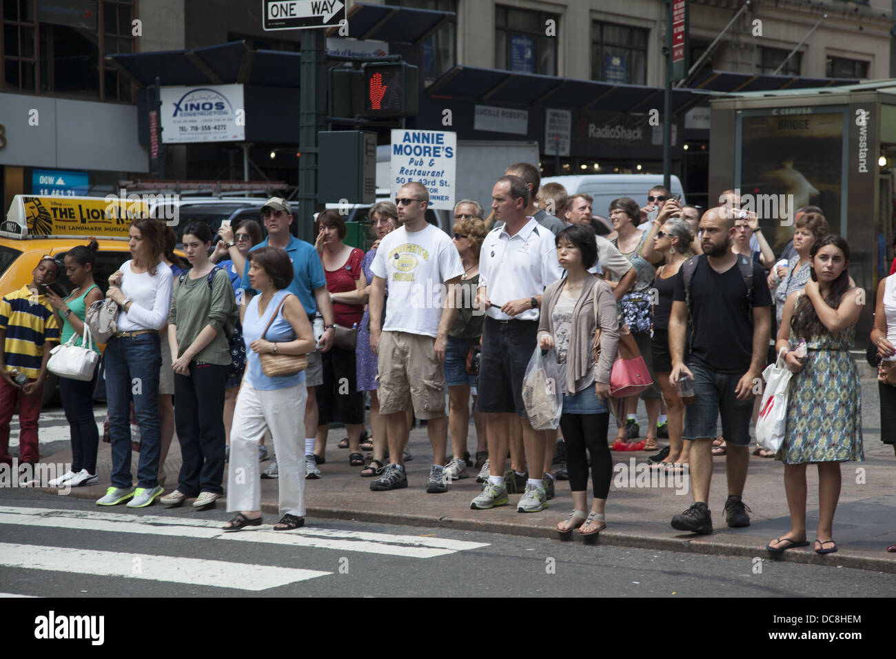 Per la maggior parte dei turisti estivi attendere il segnale a piedi per attraversare la strada sulla 42nd St. vicino alla Grand Central Station. Foto Stock