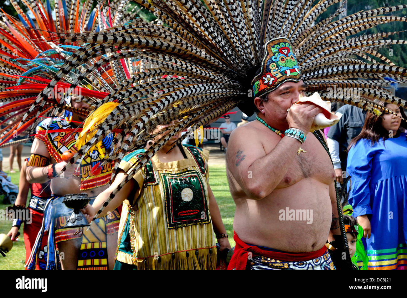 Uomo vestito da guerriero azteco soffiando una conchiglia Foto stock - Alamy