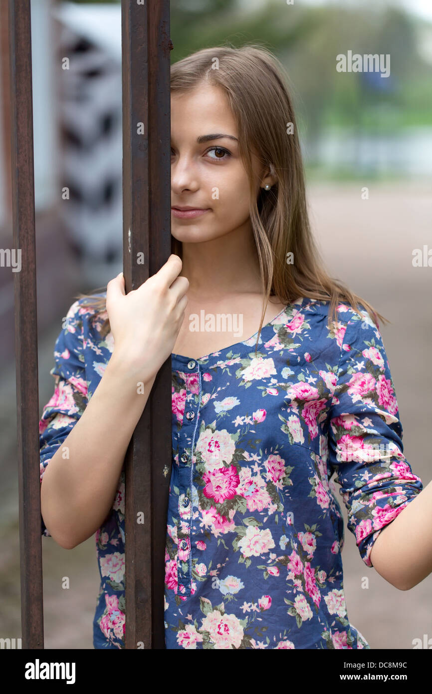 Ritratto di una bruna contro una recinzione di metallo forgiato Foto Stock