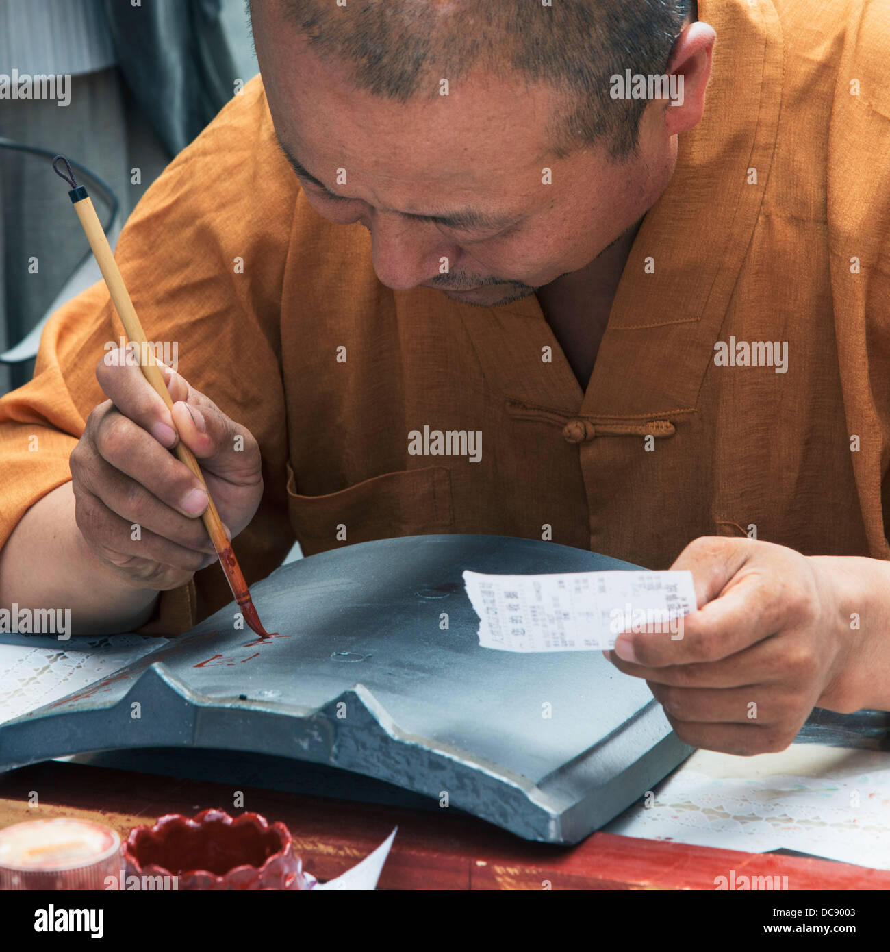 Un uomo pittura caratteri con un pennello fine corsa; Xi'an, Shaanxi, Cina Foto Stock