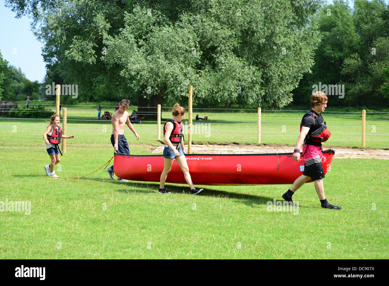 Bambini che portano i kayak torna al capannone in barca sul fiume Tamigi, Pangbourne, Berkshire, Inghilterra. Regno Unito Foto Stock