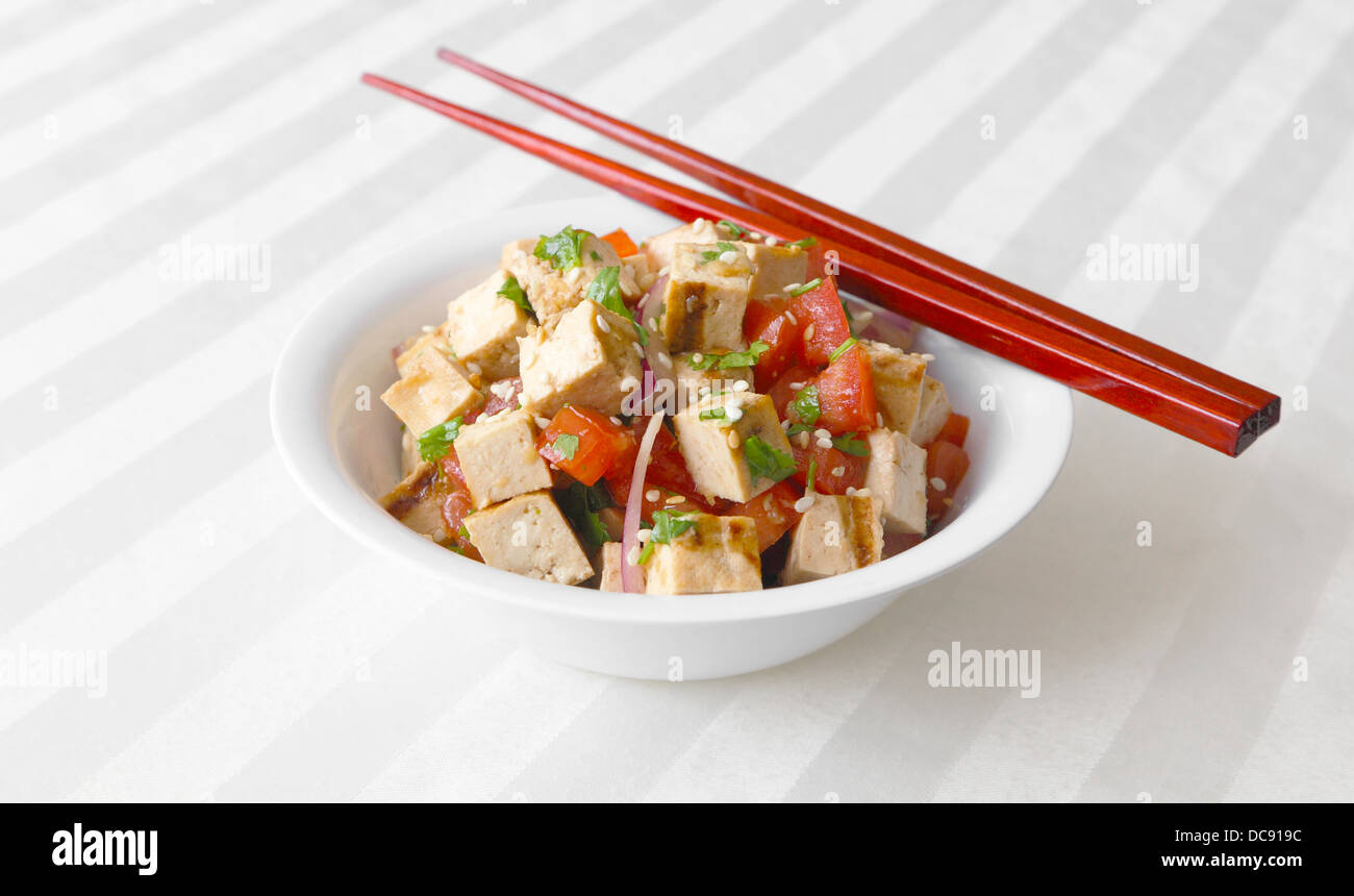 Insalata di tofu - tofu grigliato gettato insieme con i pomodori, le cipolle e coriandolo. Foto Stock