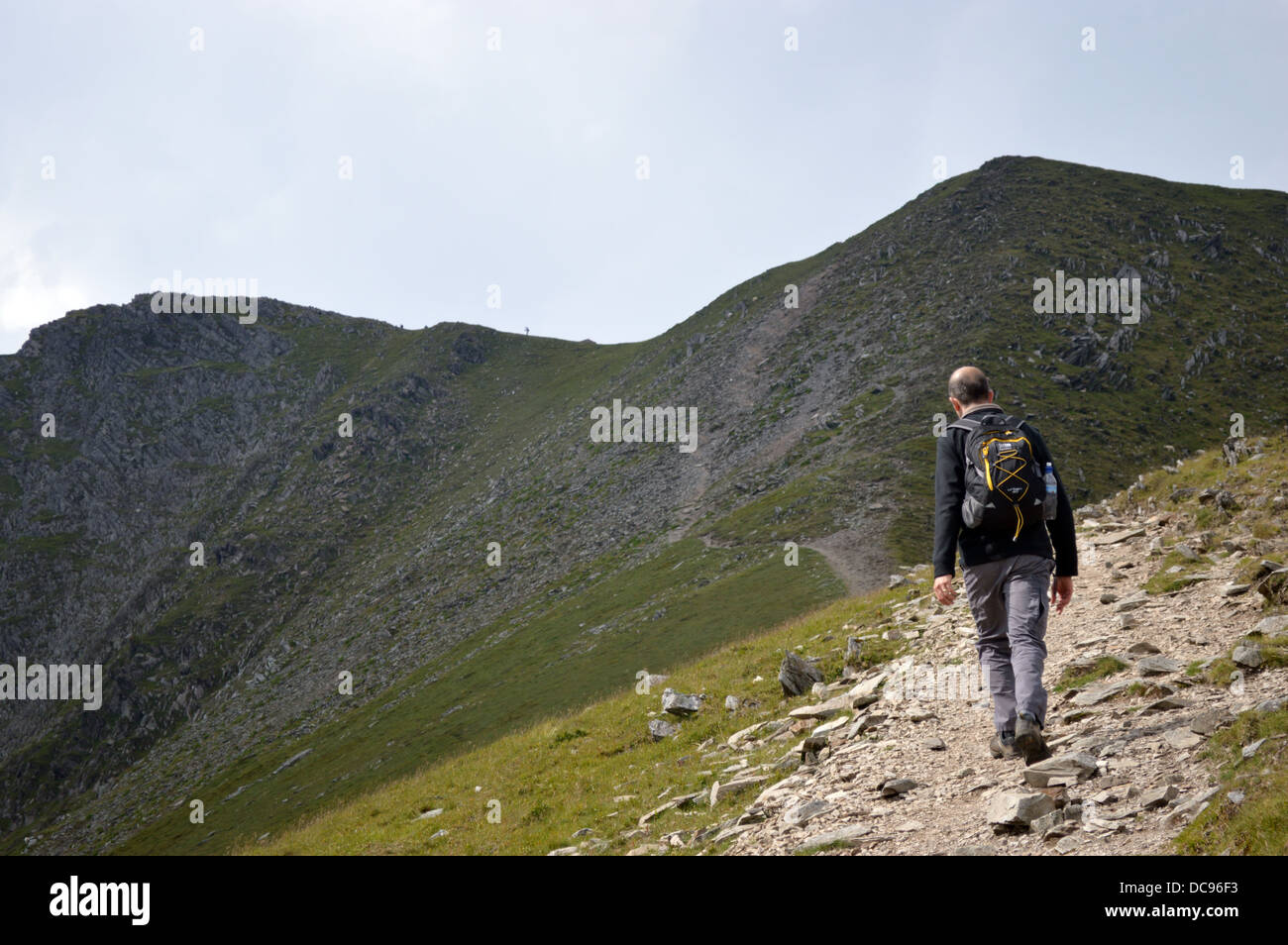 Walker sul sentiero avvicinarsi al vertice della montagna gallese Y Garn nel Parco Nazionale di Snowdonia Foto Stock