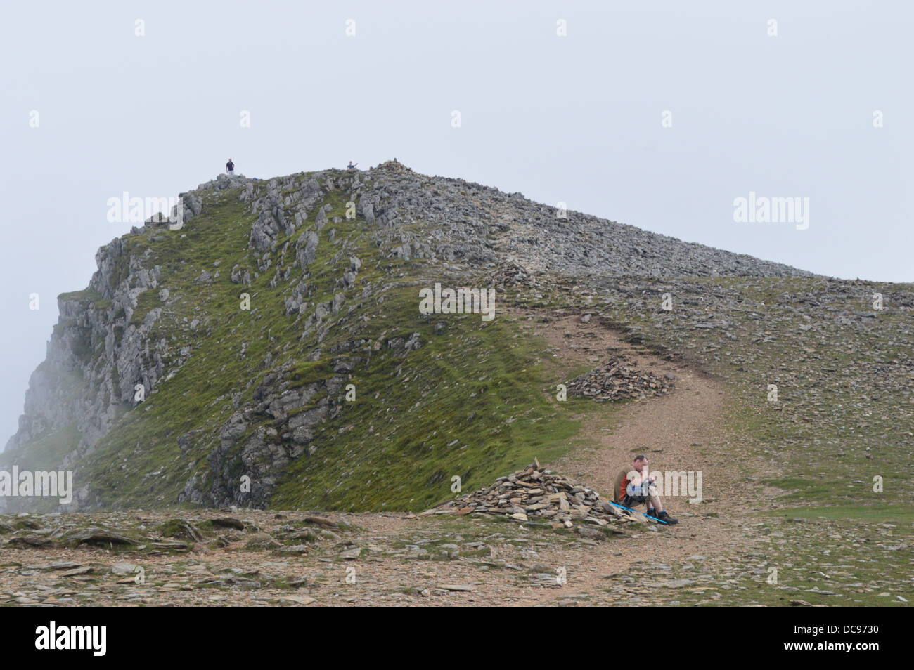 Walker in appoggio appena sotto la cima della montagna di gallese Y Garn nel Parco Nazionale di Snowdonia Foto Stock