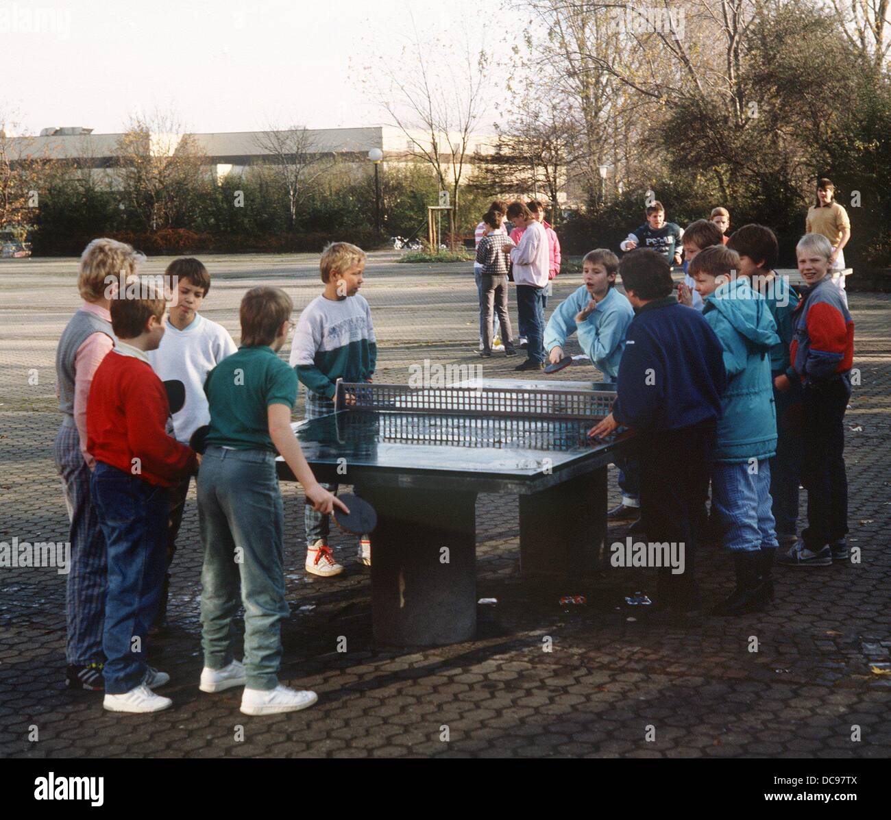 Un gruppo di alunni giochi ping pong in schoolyard (immagine dal gennaio del 1989). Foto Stock