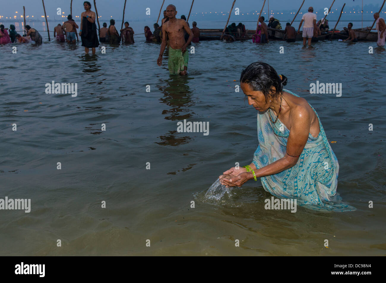 Donna prendendo un bagno nel Sangam, alla confluenza dei fiumi Gange e Yamuna e Saraswati, nelle prime ore del mattino, Kumbha Mela Foto Stock
