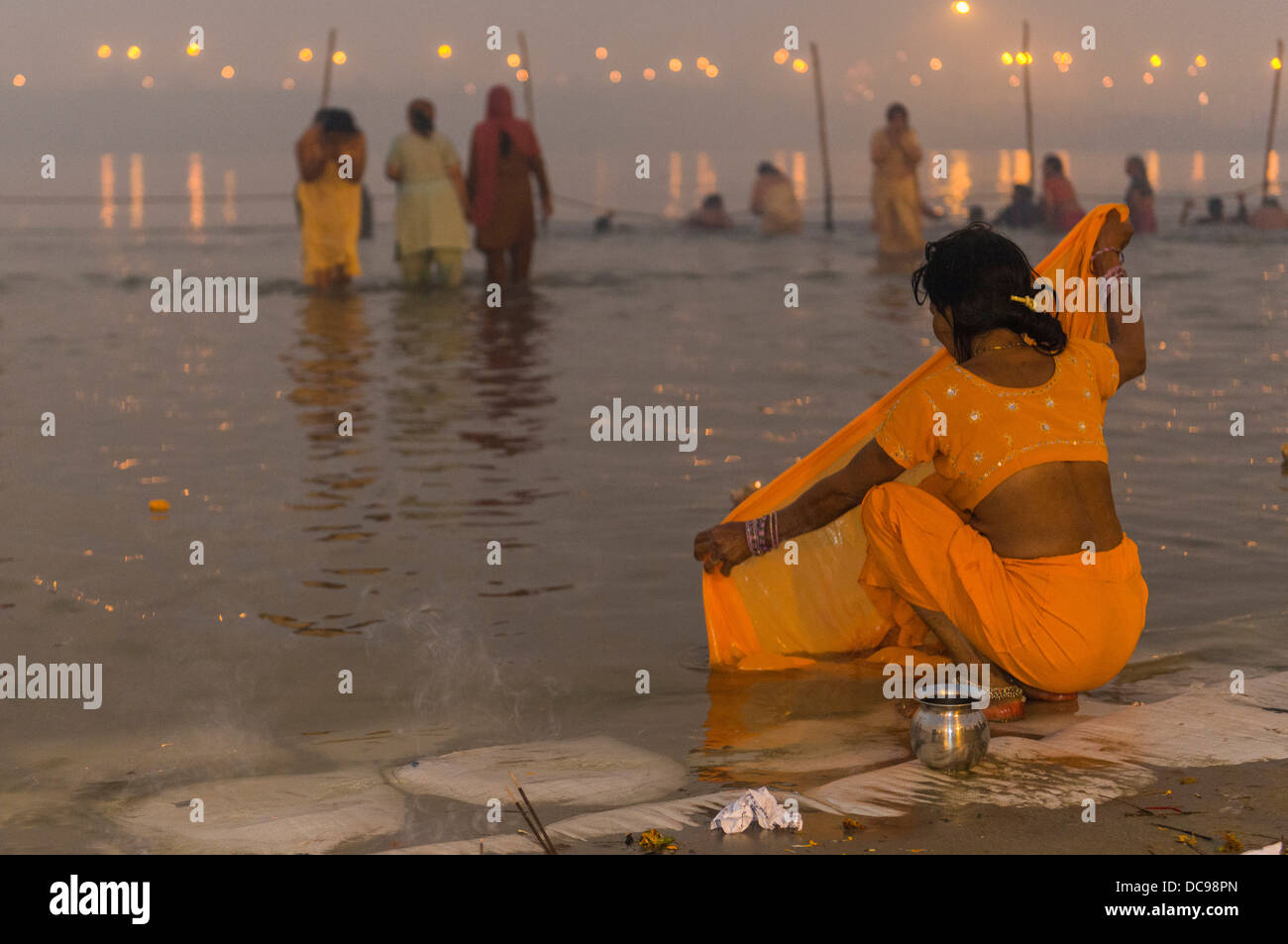 Donna lavando il suo sari in Sangam, alla confluenza dei fiumi Gange e Yamuna e Saraswati, Kumbha Mela indù di massa Foto Stock