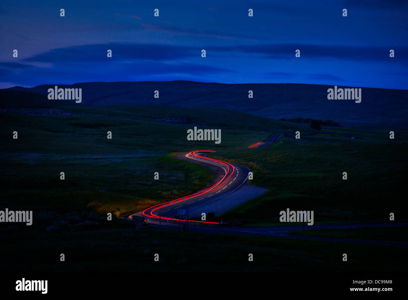 Una lunga esposizione dei fari delle auto al viadotto Ribblehead, Ingleborough riserva naturale nazionale, nello Yorkshire. B6255 sleights bassa road. Foto Stock