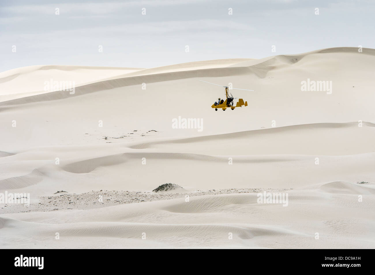 Piccolo elicottero volando sopra le dune Foto Stock