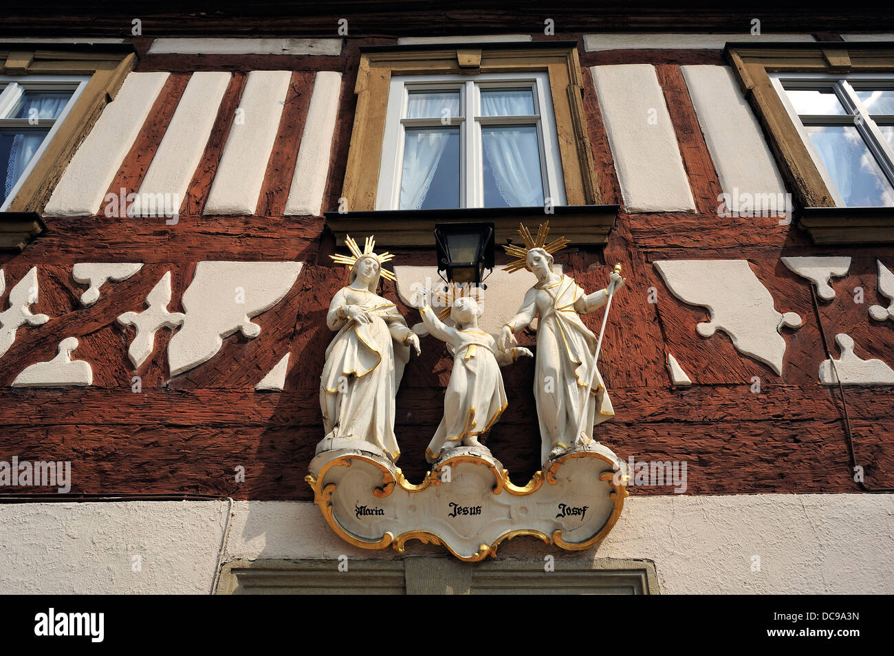 Statue di santi, la Santa Famiglia, su una casa in legno e muratura Foto Stock