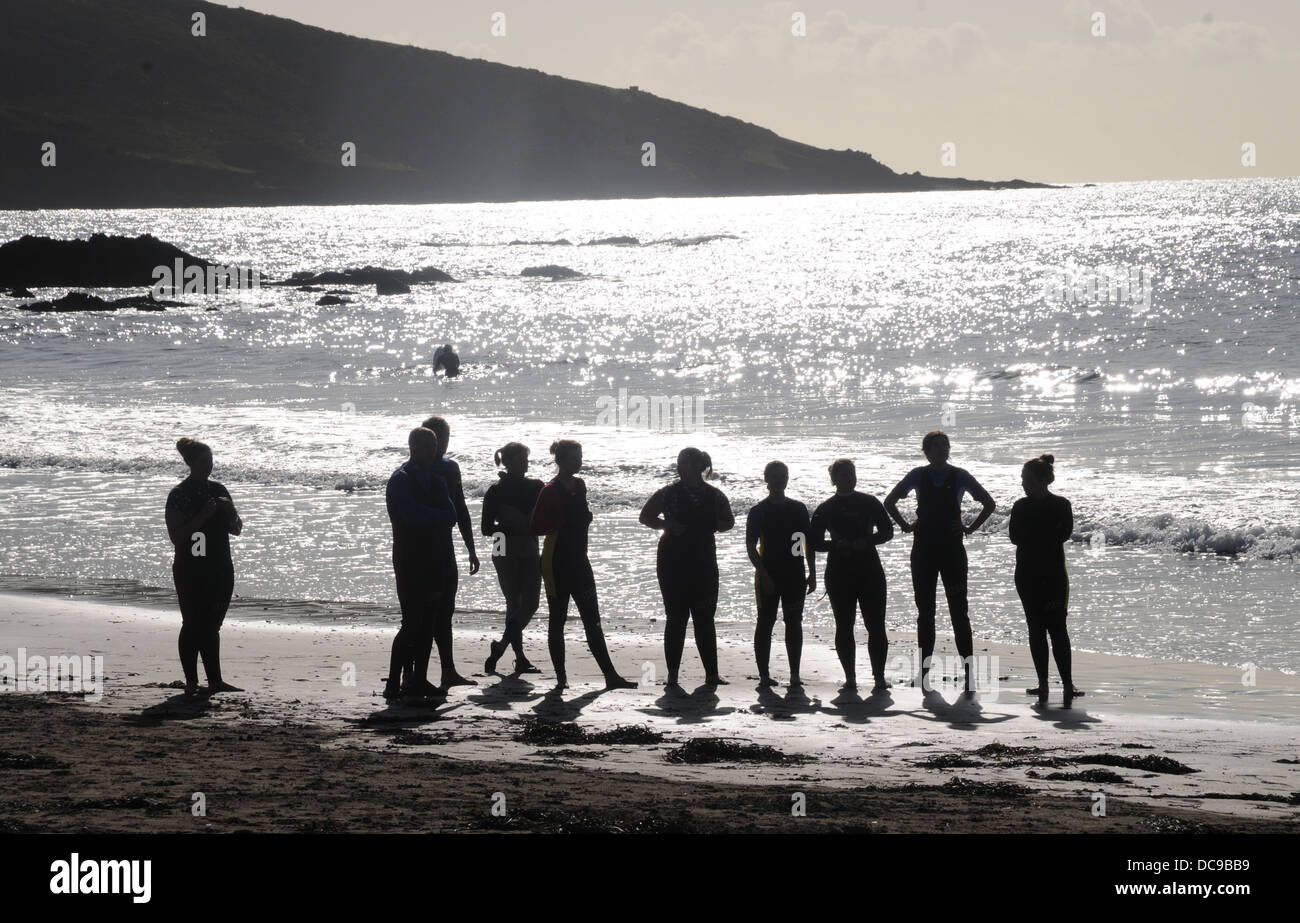 Surfisti in loro vestiti bagnati scrutando oltre il mare invitante -Wembury - Devon Foto Stock