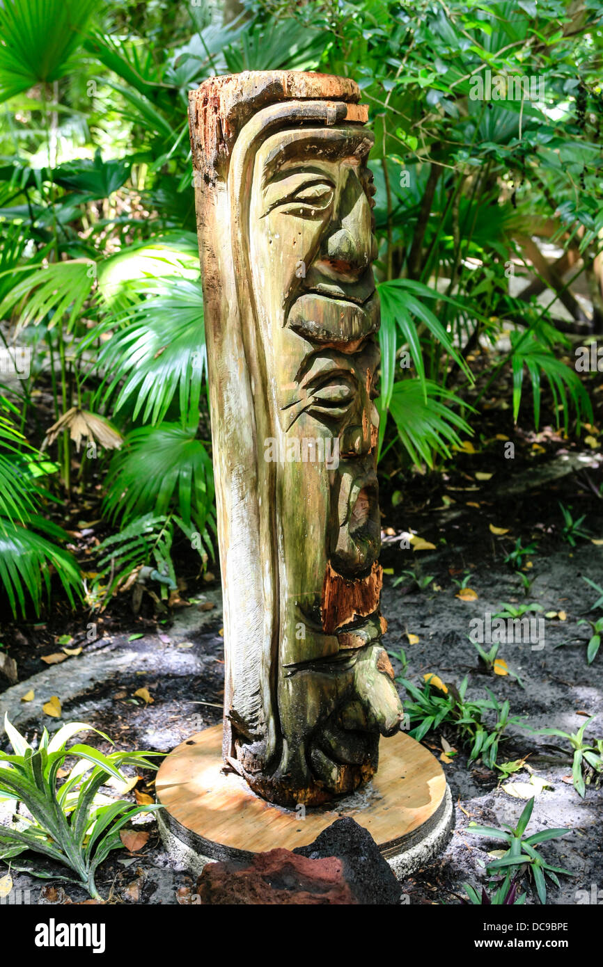 Tiki polinesiano in legno intagliato carving sul display in un giardino giungla Foto Stock