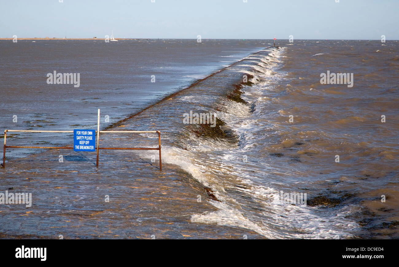 Lavaggio onde oltre lungo frangiflutti costiere Dovercourt Harwich Essex Inghilterra Foto Stock