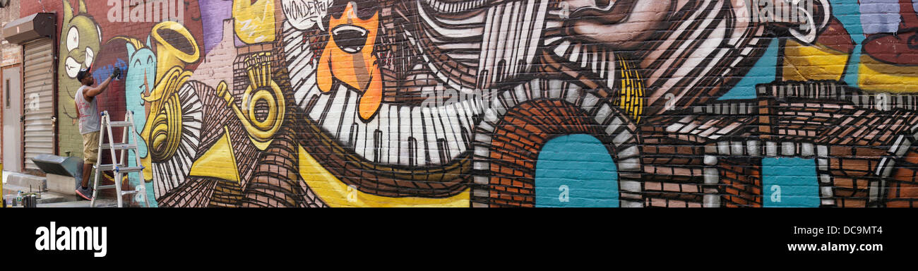 Vedere Uno dipinge il 'Follow the beat' street arte murale su una parete in Grove Vicolo nel centro di Brooklyn a New York Foto Stock