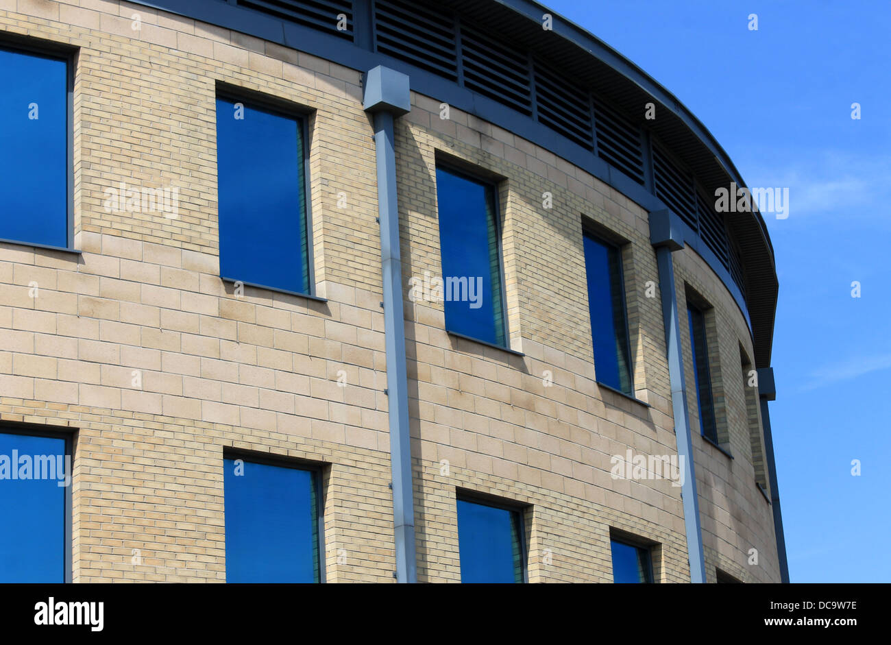 Esterno della curva ufficio moderno edificio con finestre blu. Foto Stock