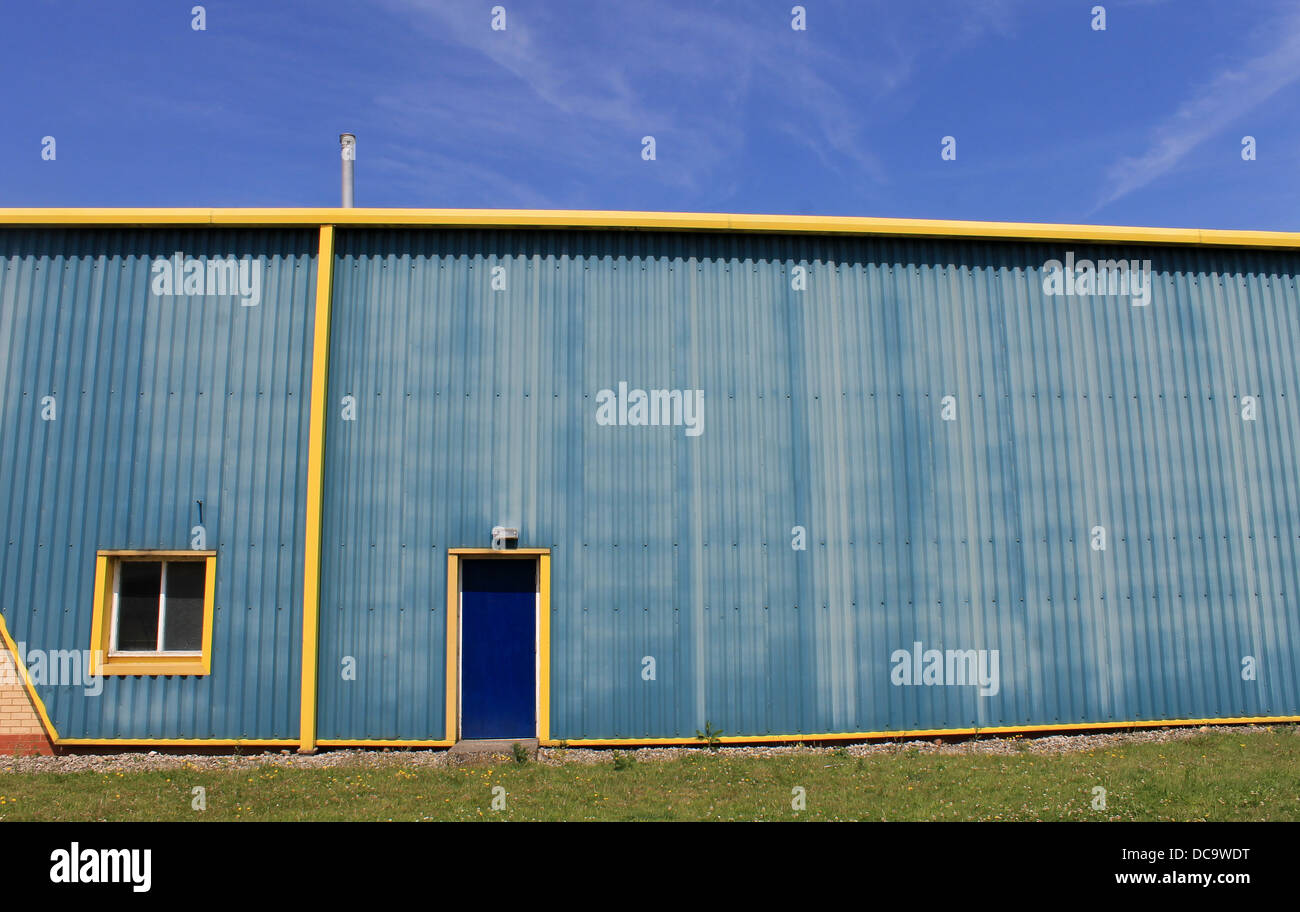 Esterno del capannone industriale in costruzione in blu e giallo. Foto Stock